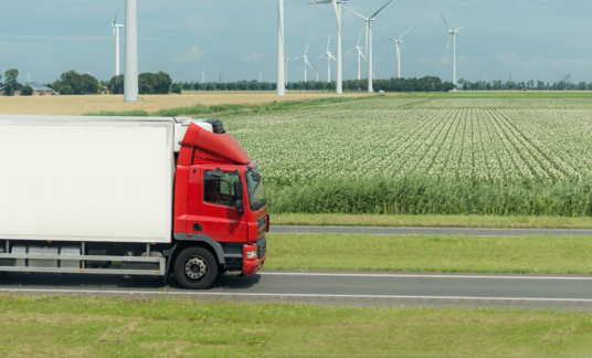 flat netherland  with truck, wind turbines and blooming crop