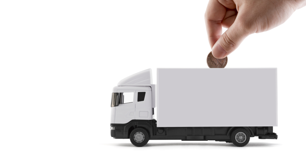 Putting coin into the white cargo delivery truck on white background