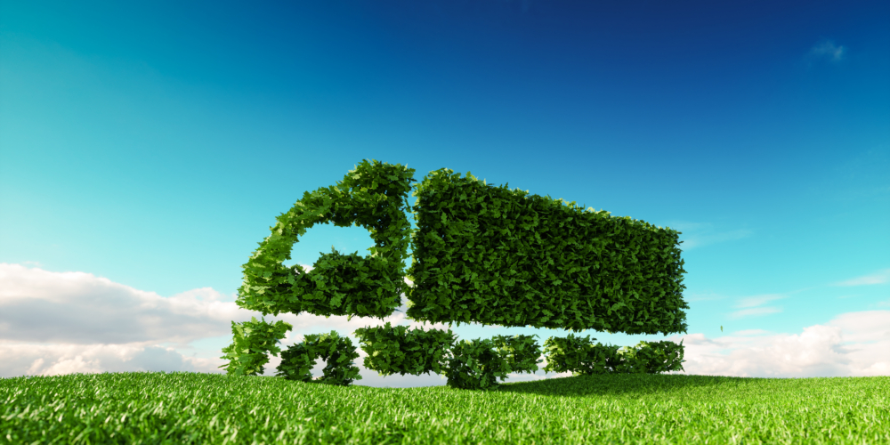 Groen – duurzaam – Elektrische truck – Eco friendly transportation concept. 3d rendering of green green truck icon on fresh spring meadow with blue sky in background.