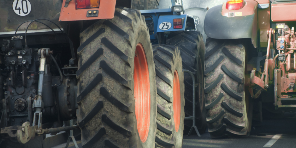 Trekkers – Rear view of multicolored tractors, wheels and engines.