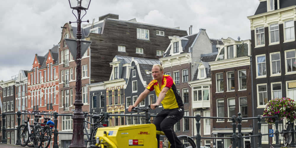 StadsdistributieStadsdistributie – Parcel Delivery Man On Bike In Amsterdam –  DHL – Fietskoerier – Cargobike – binnenstad