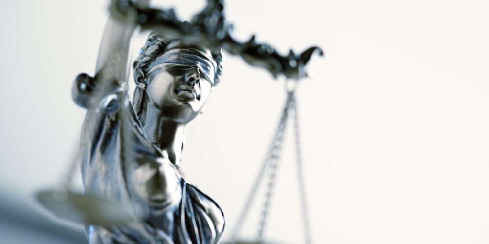 Vrouwe justitia – rechter – rechtzaak – Hof – Hoger beroep – Hoge Gerechtshof – rechtsspraak -Statue Of Lady Justice In Front Light Colored Background