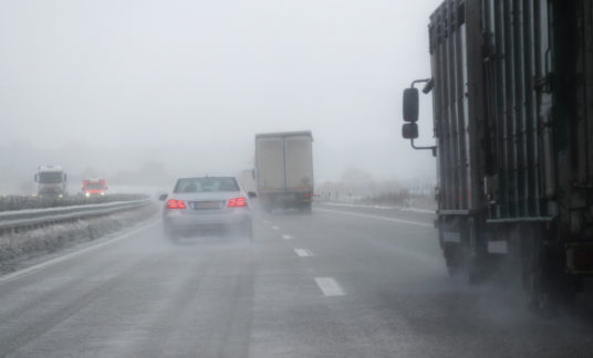 cars, trucks and rescue vehicle driving in dangerous winter weather