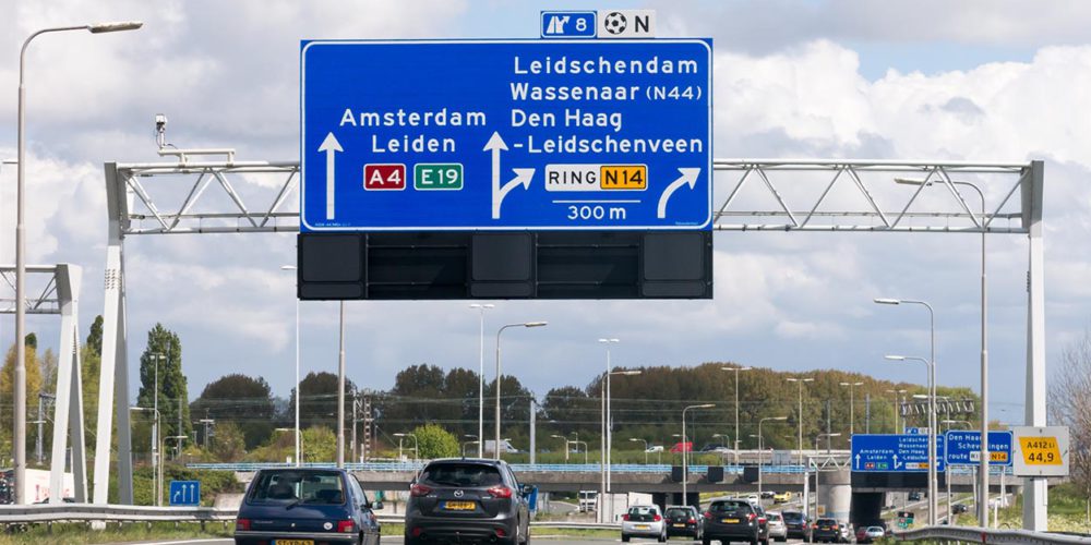 Motorway A4 with traffic and route signs, The Hague, Netherlands