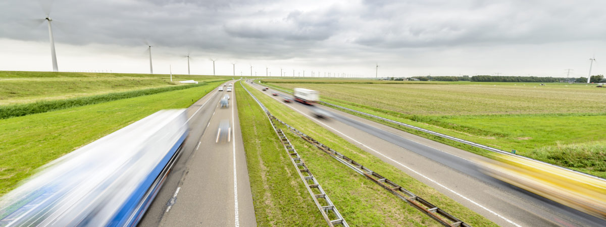Traffic on a highway in an open rural landscape with windturbines