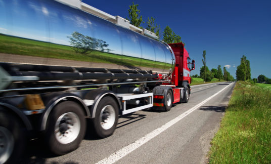 Mirroring the landscape chrome tank truck moving on a highway