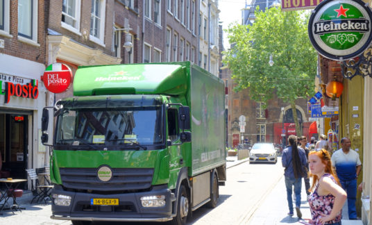 Heineken beer electric delivery truck bringing beer to bars in the narrow streets of the city center in Amsterdam